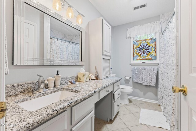 bathroom featuring vanity, tile patterned flooring, and toilet