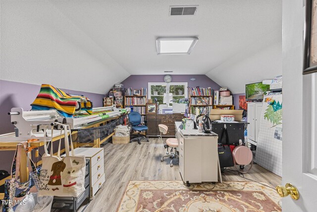 office area with light wood-type flooring and vaulted ceiling