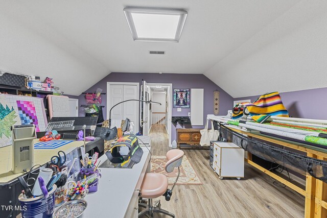 interior space featuring lofted ceiling and light hardwood / wood-style flooring