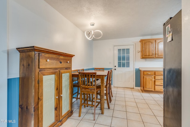 dining space with a textured ceiling and light tile patterned floors