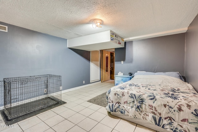 bedroom with a textured ceiling and light tile patterned floors