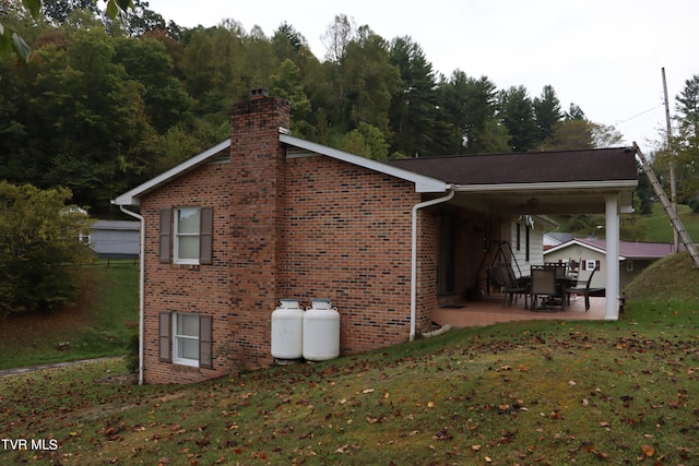 view of side of property with a lawn and a patio area