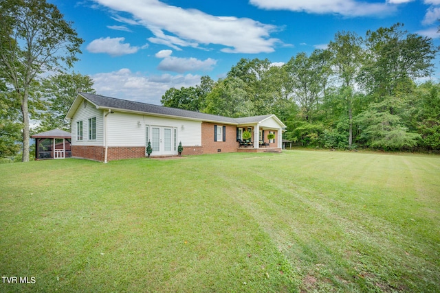 ranch-style house with a front lawn and french doors