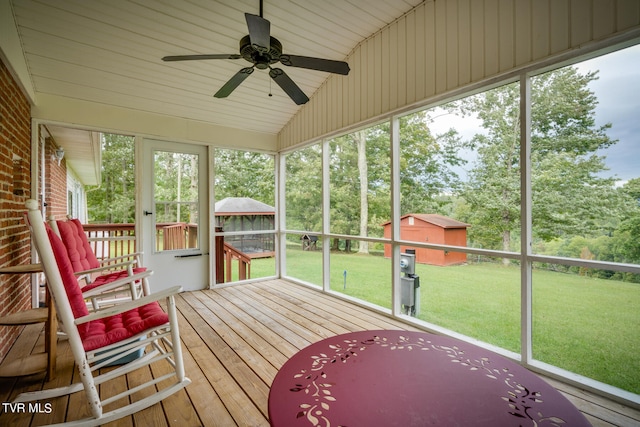 unfurnished sunroom featuring a wealth of natural light, lofted ceiling, and ceiling fan