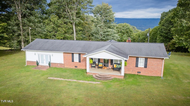 back of property featuring a yard and french doors