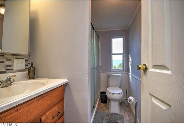 bathroom with walk in shower, ornamental molding, vanity, and toilet