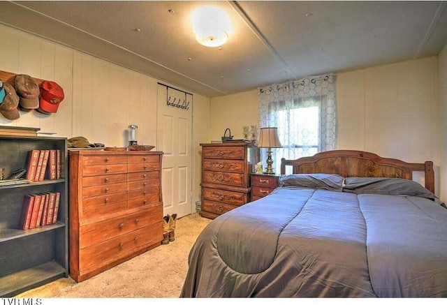 carpeted bedroom featuring wooden walls