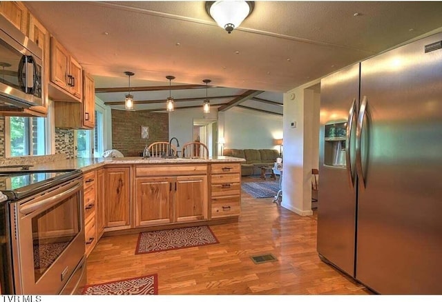 kitchen featuring vaulted ceiling with beams, hanging light fixtures, sink, light hardwood / wood-style flooring, and stainless steel appliances