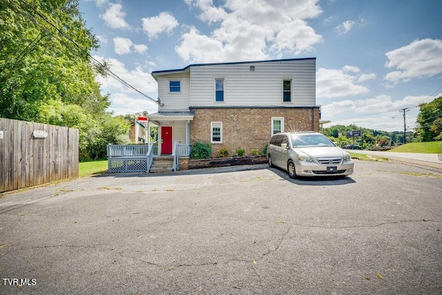 view of front of home featuring fence and brick siding