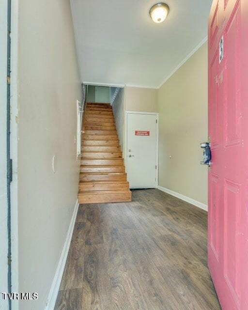 foyer entrance featuring stairway, ornamental molding, baseboards, and wood finished floors