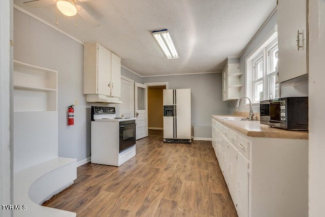 kitchen featuring a sink, open shelves, under cabinet range hood, wood finished floors, and white appliances