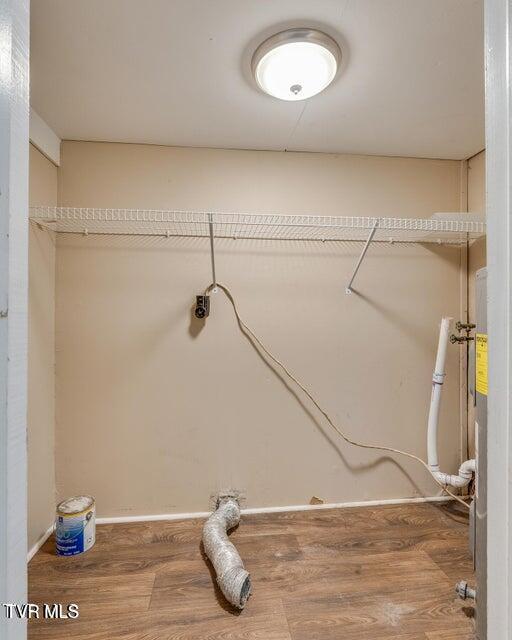 laundry area with laundry area, wood finished floors, and electric dryer hookup