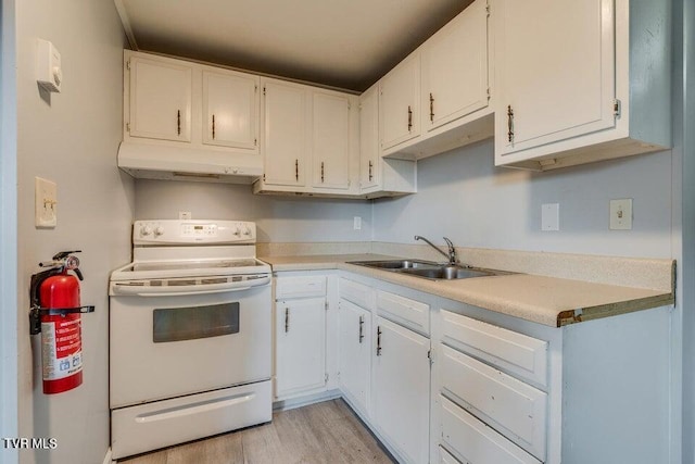 kitchen featuring electric range, a sink, light countertops, white cabinets, and under cabinet range hood