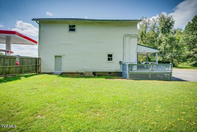 back of property with a yard, a deck, and fence