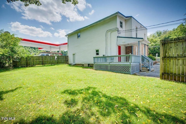 back of house featuring a yard and fence