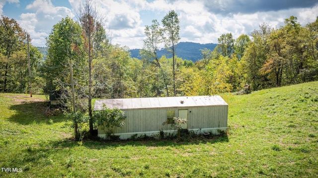 exterior space with a view of trees, a pole building, an outdoor structure, and a lawn