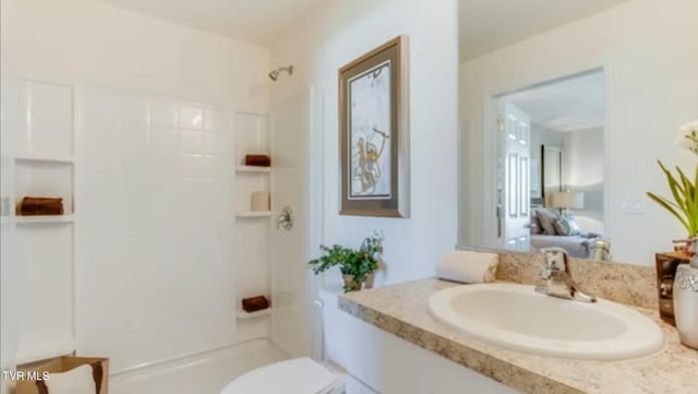 bathroom featuring vanity, toilet, and walk in shower