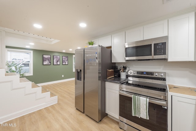 kitchen featuring light wood-type flooring, white cabinetry, and appliances with stainless steel finishes