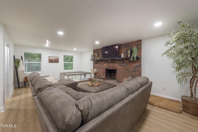 living room with a fireplace and light wood-type flooring