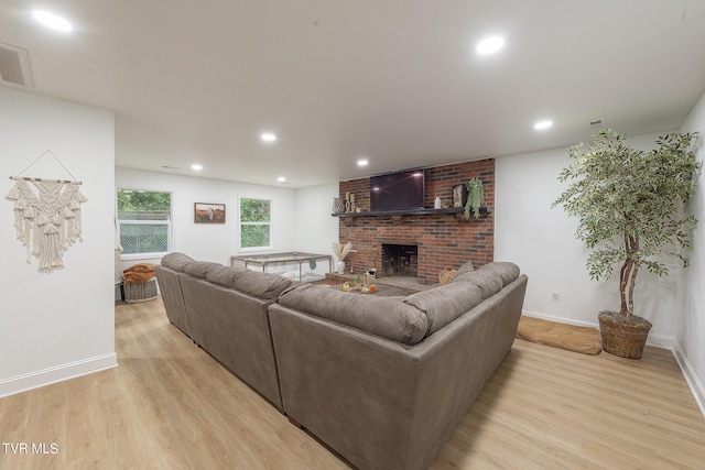 living room with light hardwood / wood-style floors and a fireplace