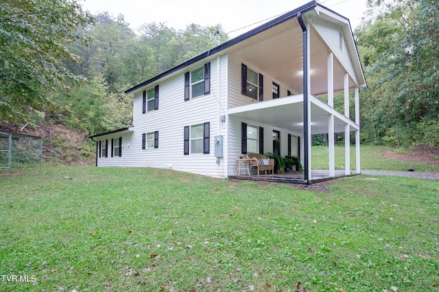 rear view of property featuring a patio and a lawn