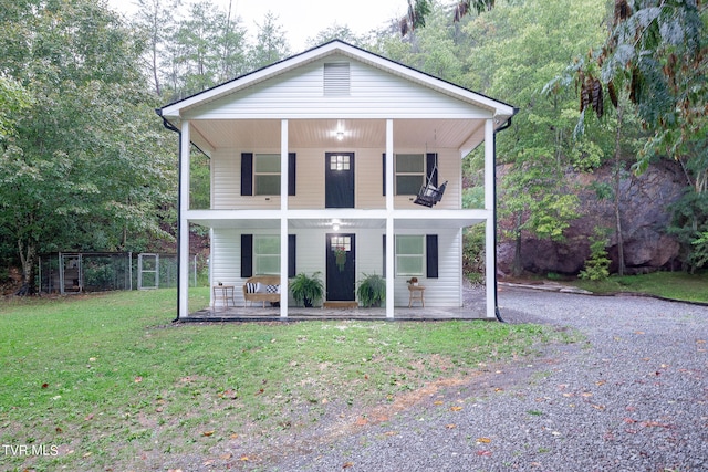 view of property with covered porch and a front lawn