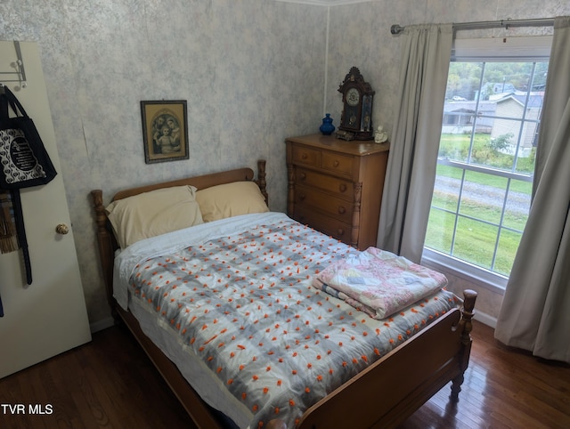 bedroom with dark wood-type flooring and multiple windows