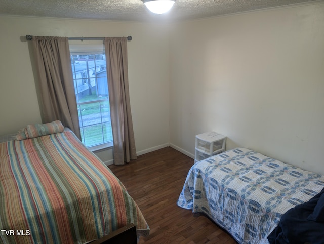 bedroom with a textured ceiling, multiple windows, and dark hardwood / wood-style flooring