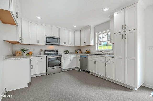 kitchen with stainless steel appliances, white cabinets, and sink