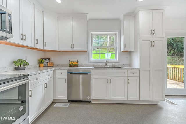 kitchen with stainless steel appliances, white cabinets, and sink