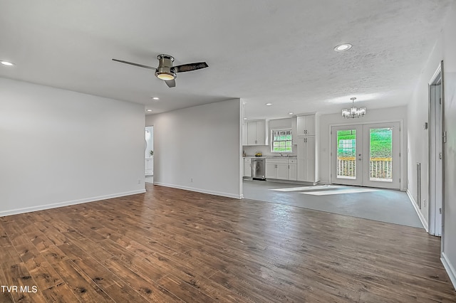 unfurnished living room featuring ceiling fan with notable chandelier, a textured ceiling, hardwood / wood-style flooring, and sink