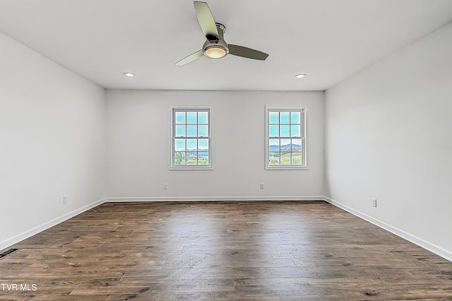 unfurnished room featuring ceiling fan and dark wood-type flooring