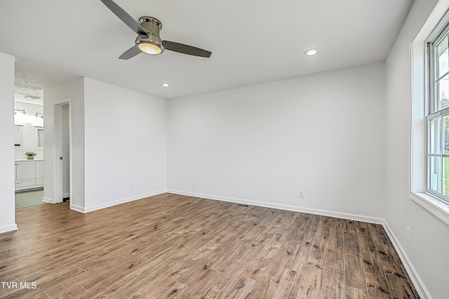 empty room featuring light wood-type flooring, ceiling fan, and plenty of natural light