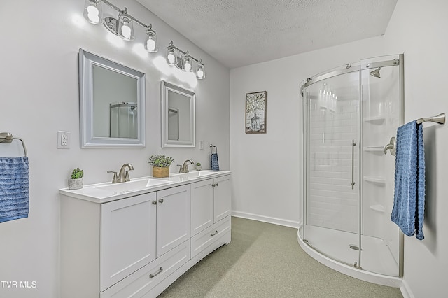 bathroom featuring a textured ceiling, walk in shower, and vanity