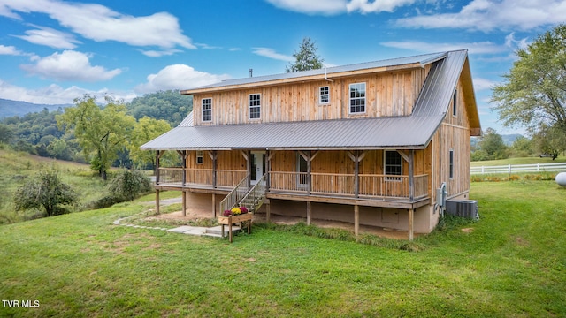 view of front of house featuring covered porch, central air condition unit, and a front lawn