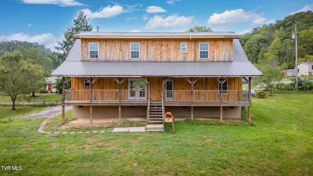 back of property with covered porch and a lawn