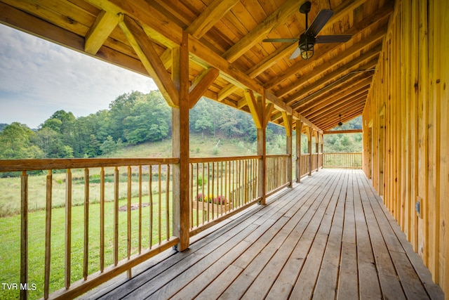 wooden terrace featuring a lawn and ceiling fan