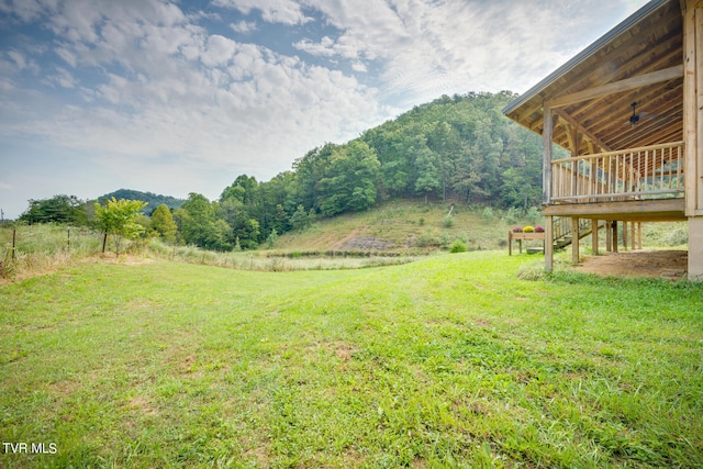 view of yard with a wooden deck and a rural view