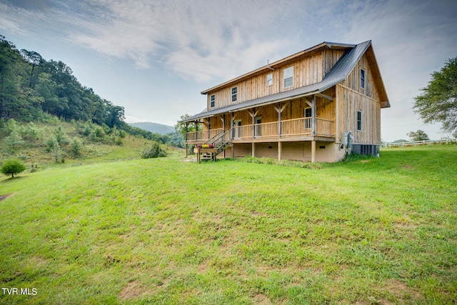 back of house with a yard, covered porch, and central air condition unit