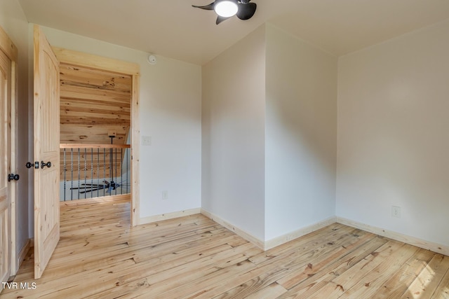unfurnished room with baseboards, a ceiling fan, and wood-type flooring