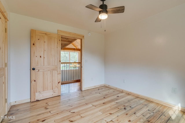 spare room featuring ceiling fan, lofted ceiling, and light hardwood / wood-style flooring