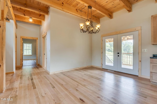 unfurnished dining area featuring french doors, wooden ceiling, beam ceiling, and light wood-type flooring