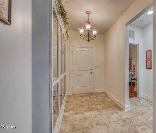 doorway to outside with a chandelier