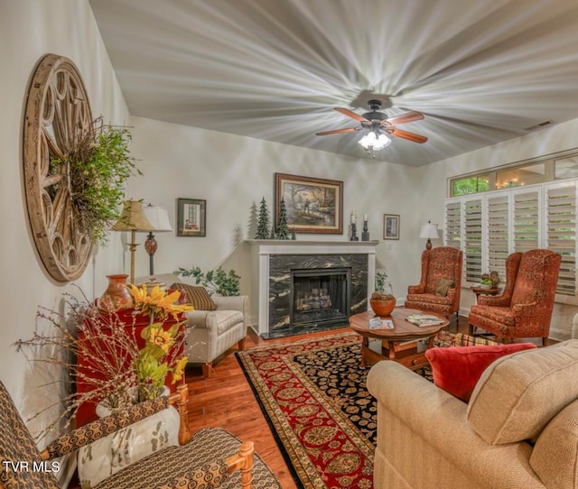 living room featuring a fireplace, hardwood / wood-style flooring, and ceiling fan