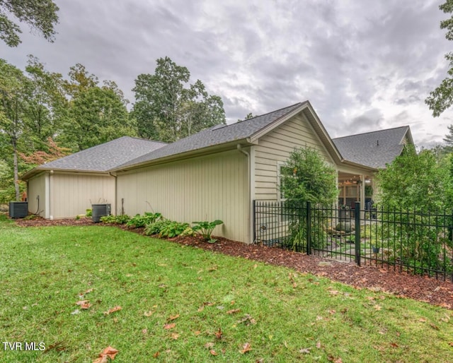 view of property exterior with central AC and a lawn