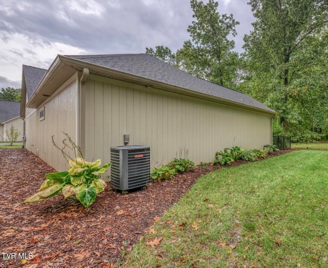 view of side of property featuring a lawn and central air condition unit