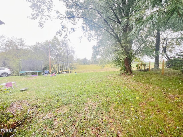 view of yard featuring a trampoline and a playground