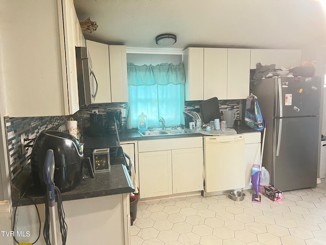 kitchen with decorative backsplash, white cabinets, appliances with stainless steel finishes, and sink