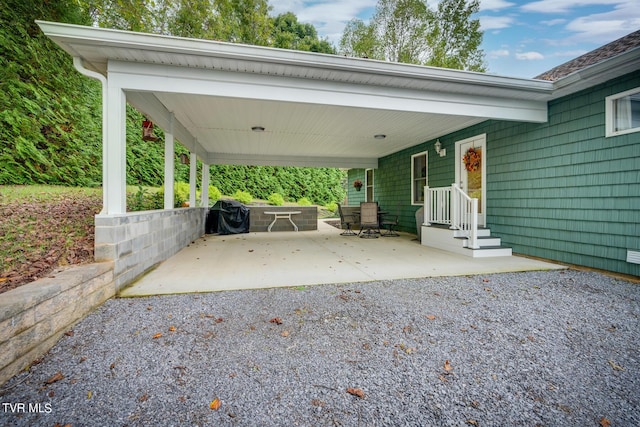 view of patio / terrace featuring area for grilling, an attached carport, and driveway