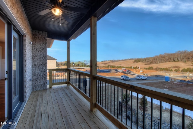 wooden terrace featuring ceiling fan and a rural view